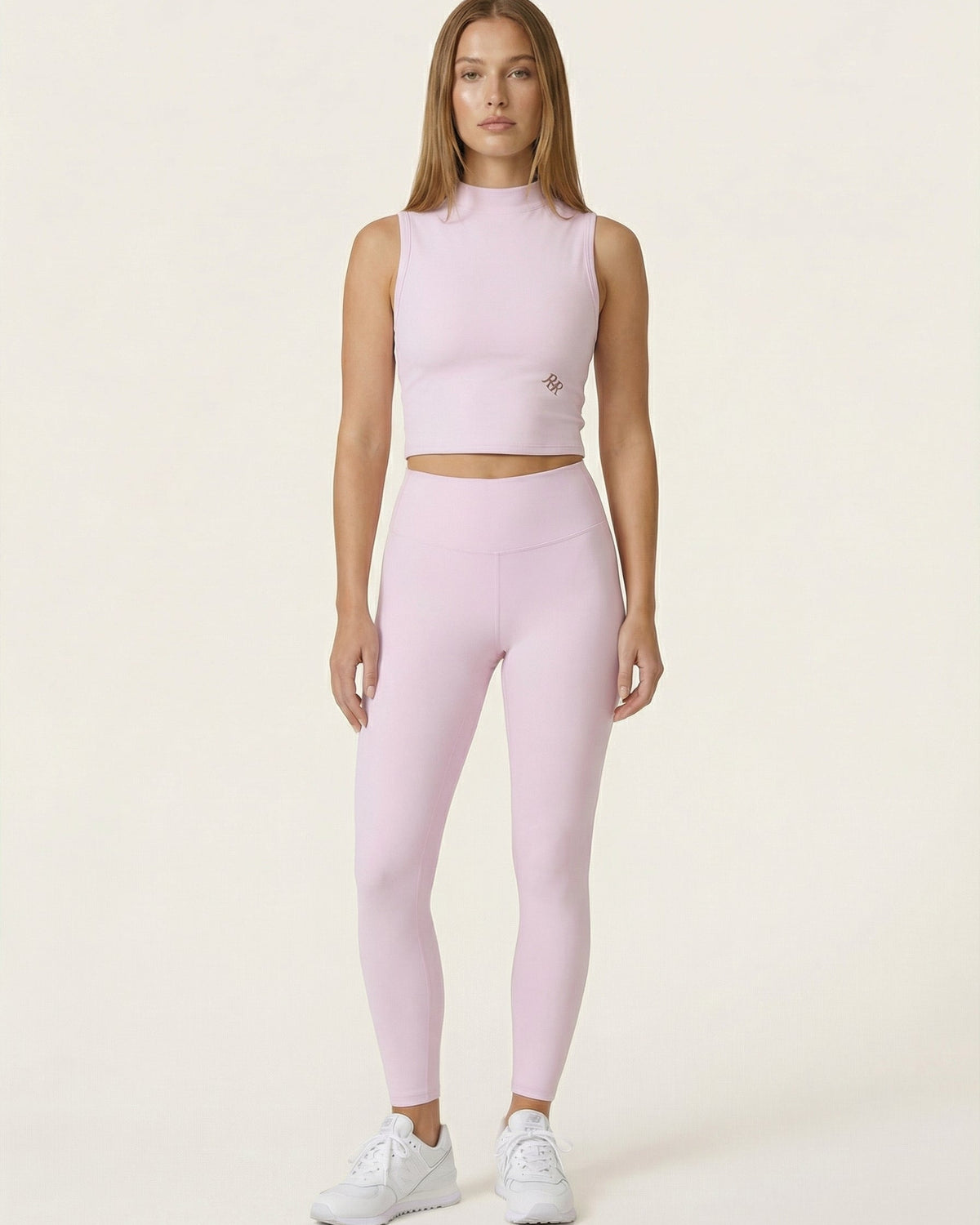 Woman wearing a pink athletic outfit on a white background