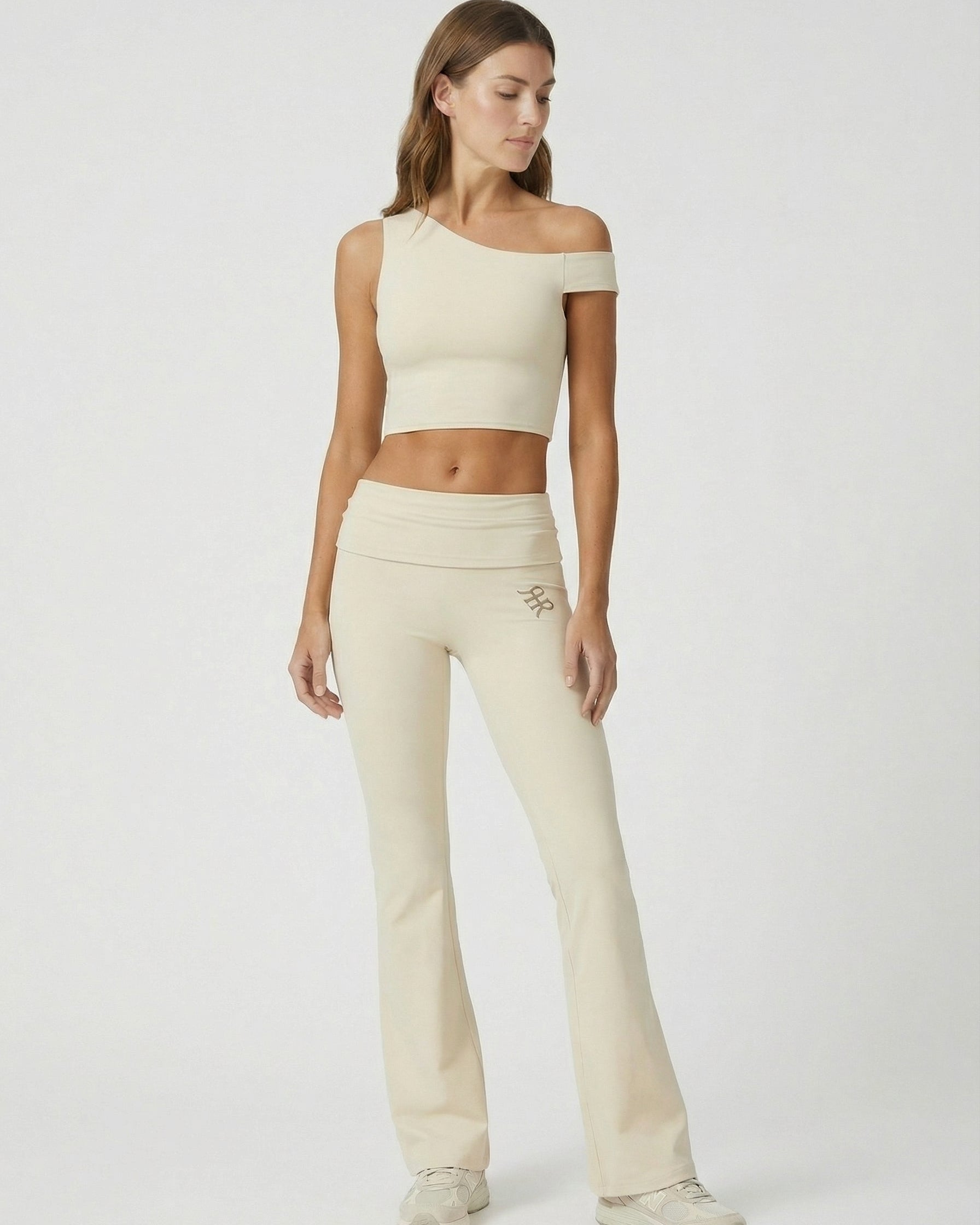 Woman wearing a beige athletic outfit on a white background