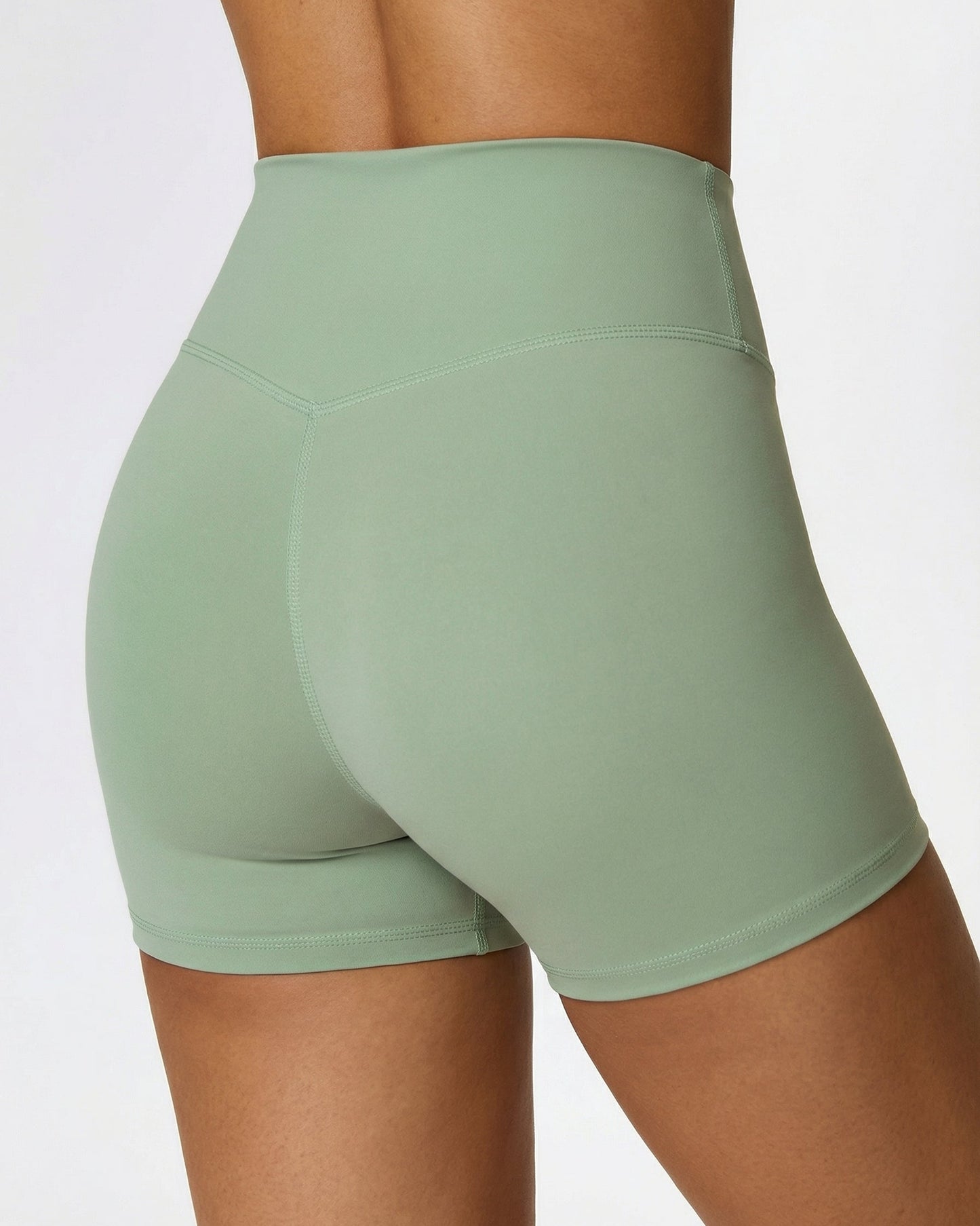 Green athletic shorts worn by a person on a light gray background