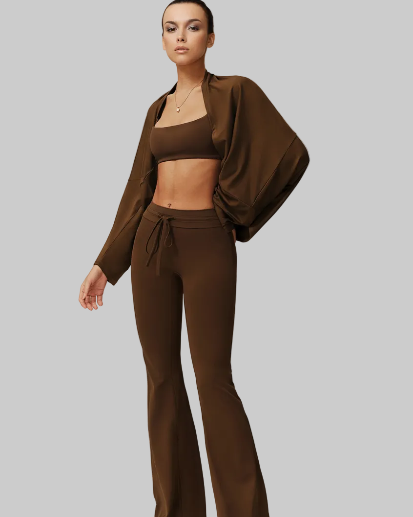 Woman wearing a brown outfit with a matching jacket on a plain background