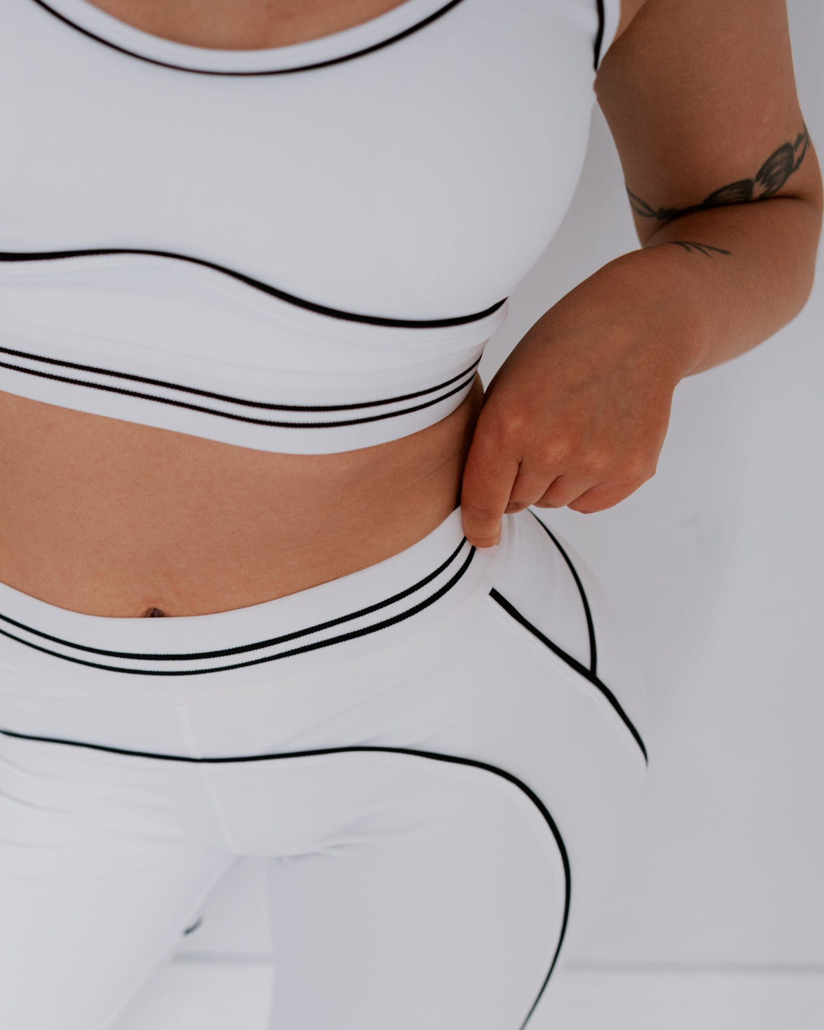 Person wearing a white outfit with black line design on a light gray background