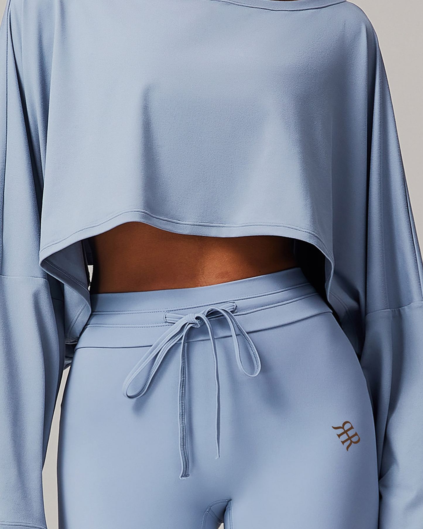 Light blue long-sleeve top and leggings set on a neutral background