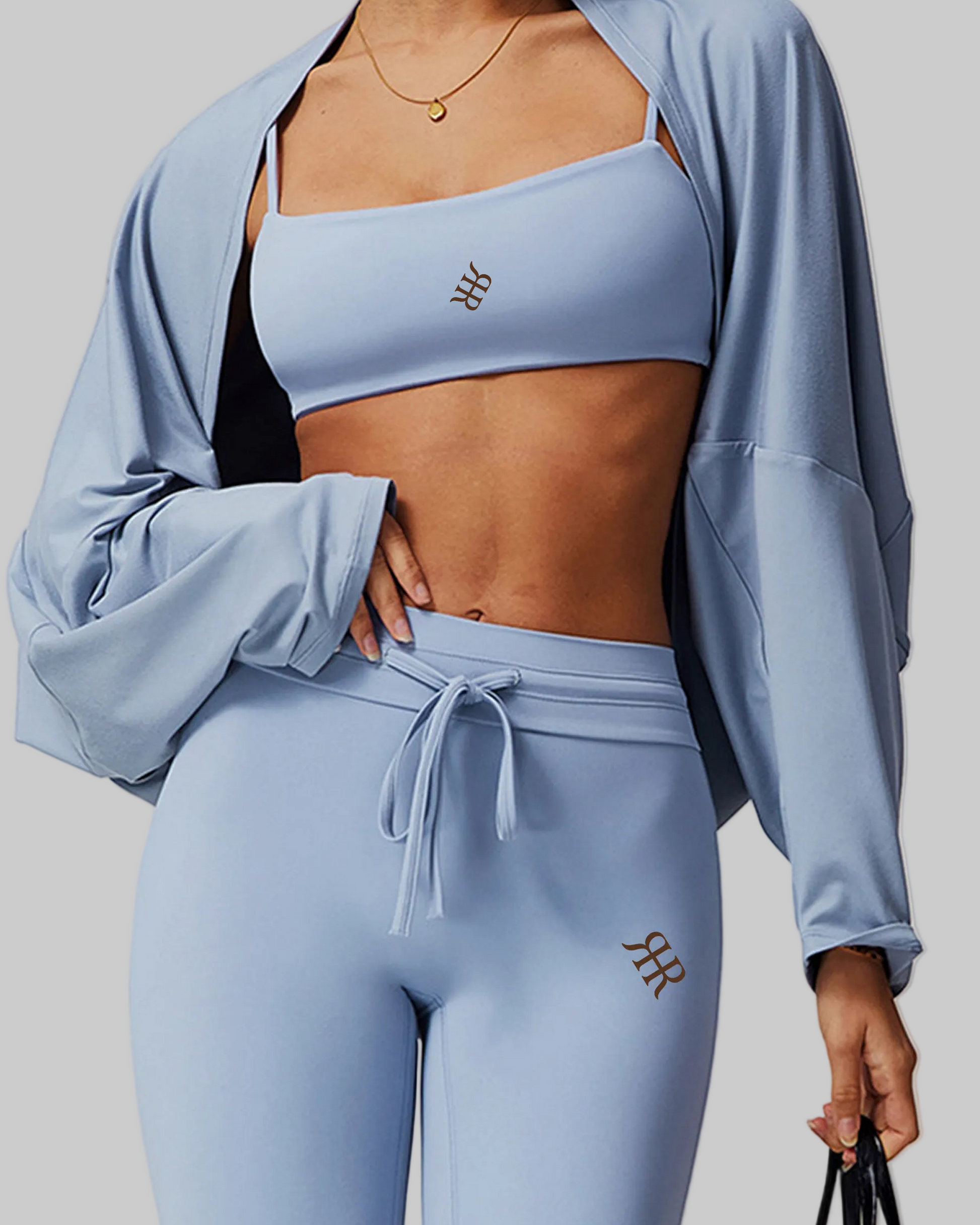 Person wearing a light blue athletic outfit with a matching jacket on a plain background