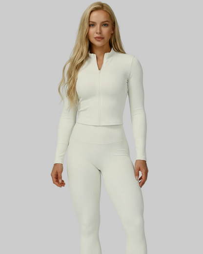 Woman wearing white ribbed compression jacket, racerback tank, and high-waisted leggings from the Soft Power Set.
