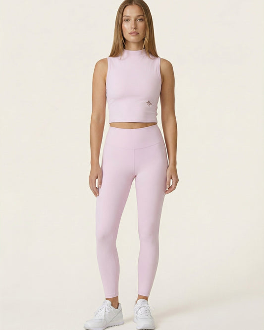Woman wearing a pink athletic outfit on a white background