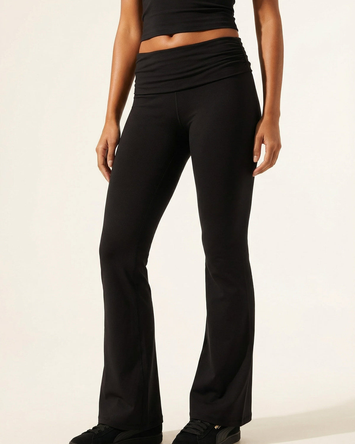 Person wearing black pants on a plain background