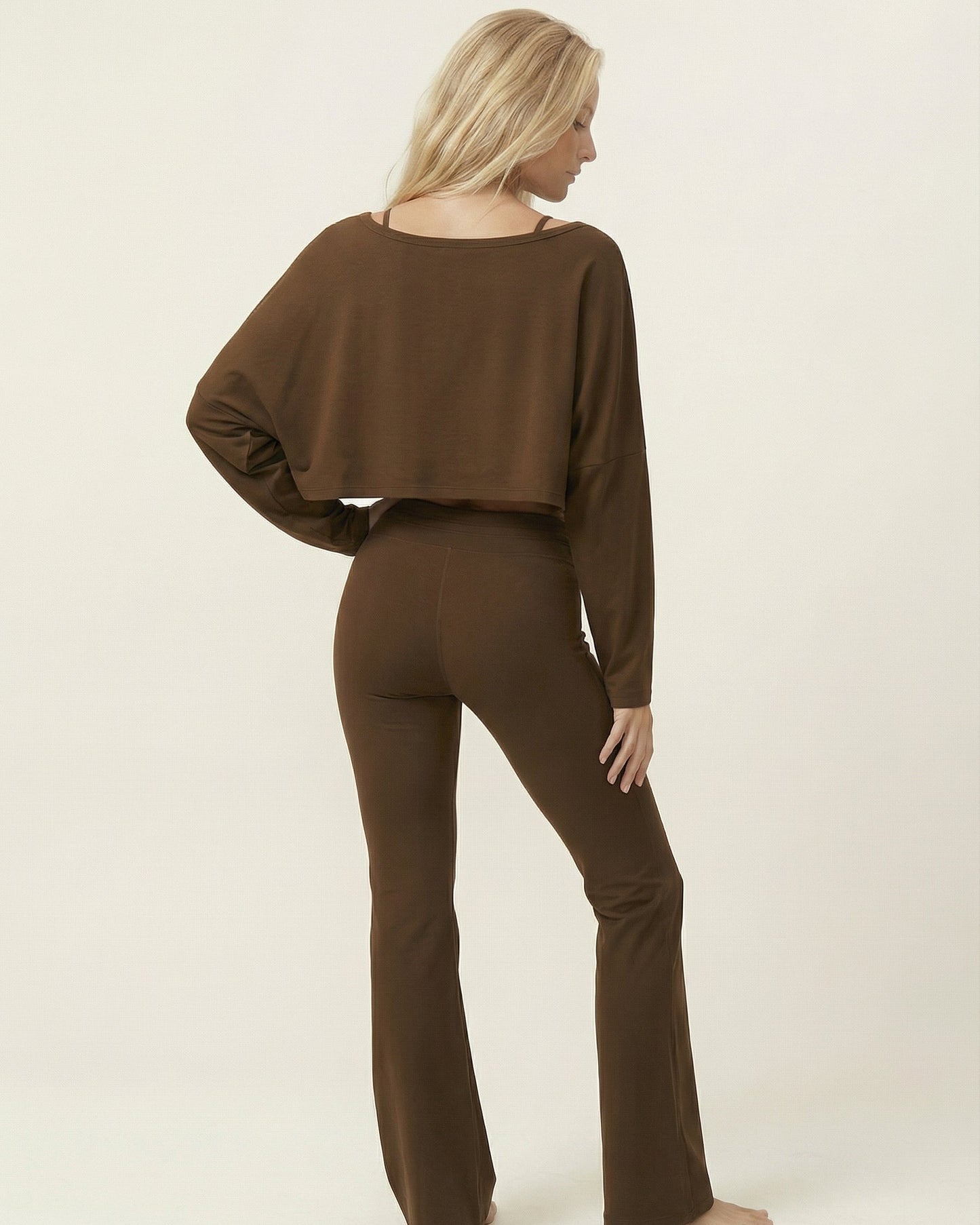Woman wearing a brown outfit on a plain background