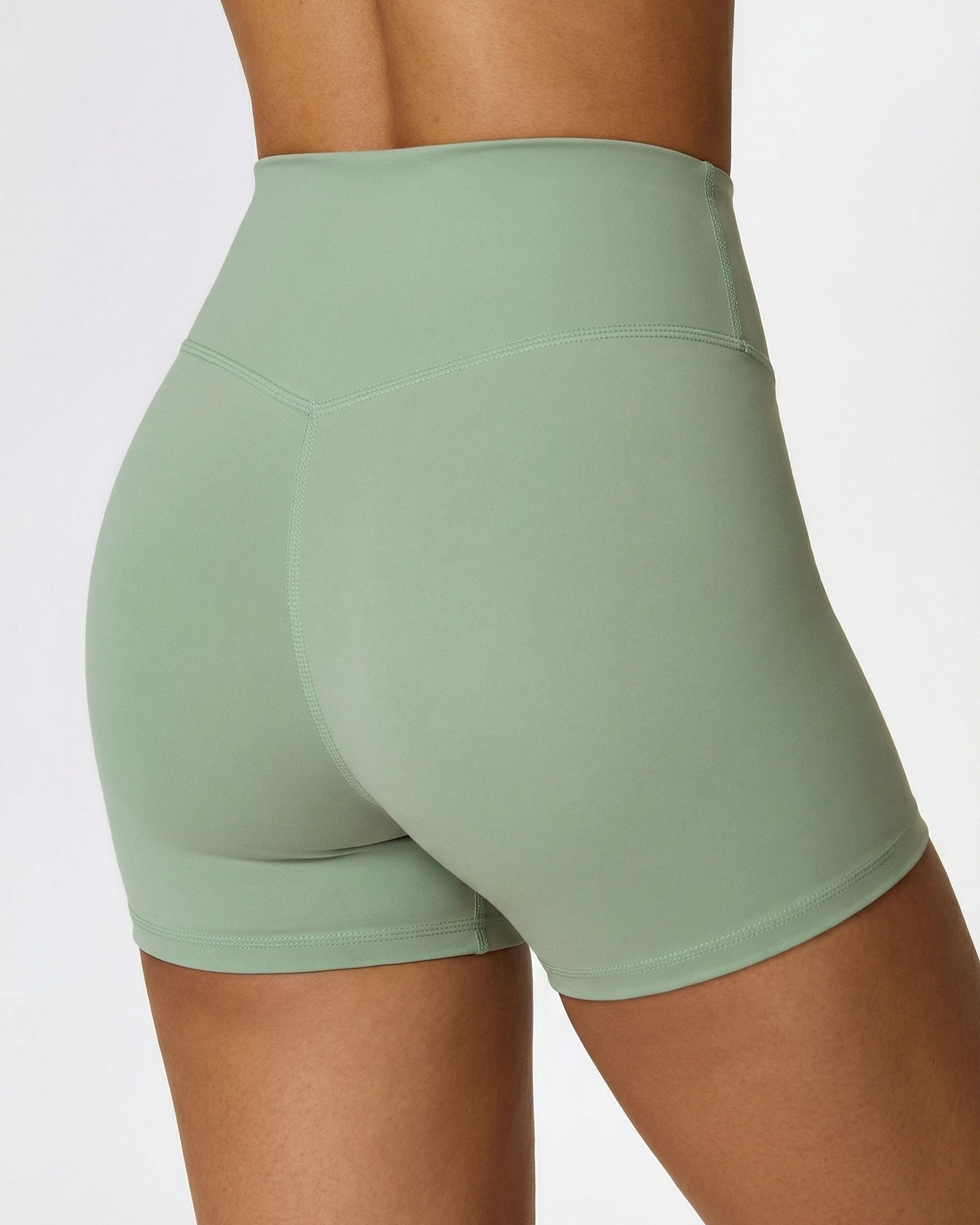 Green athletic shorts worn by a person on a light gray background