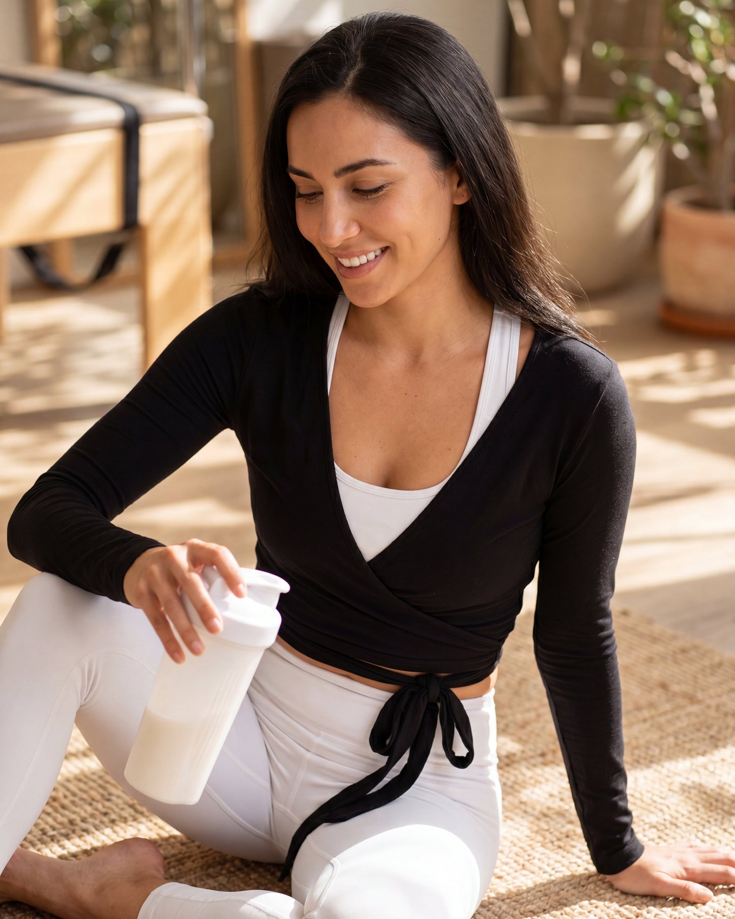 Woman in athletic wear holding a water bottle outdoors